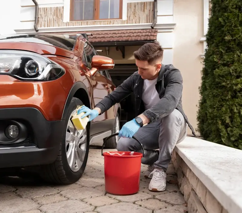 Lavage auto à domicile Fontenay-le-Pesnel : professionnel intervenant sur un véhicule
